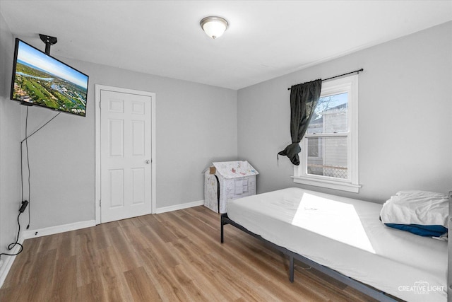 bedroom featuring wood finished floors and baseboards