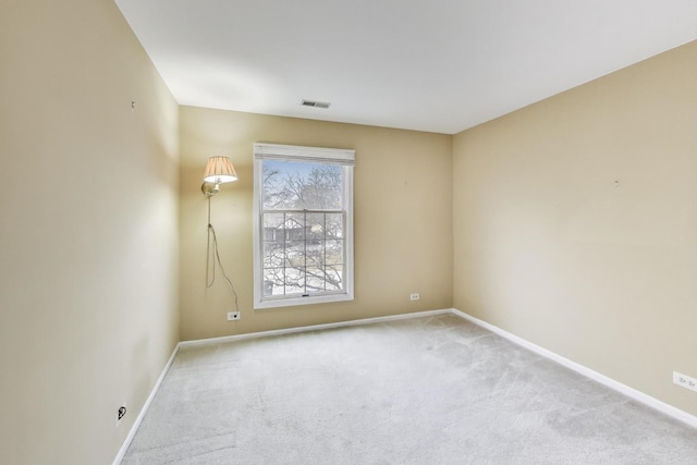 carpeted empty room featuring baseboards and visible vents