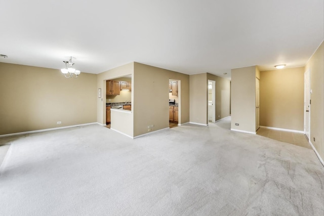 unfurnished living room featuring light carpet, visible vents, baseboards, and a notable chandelier