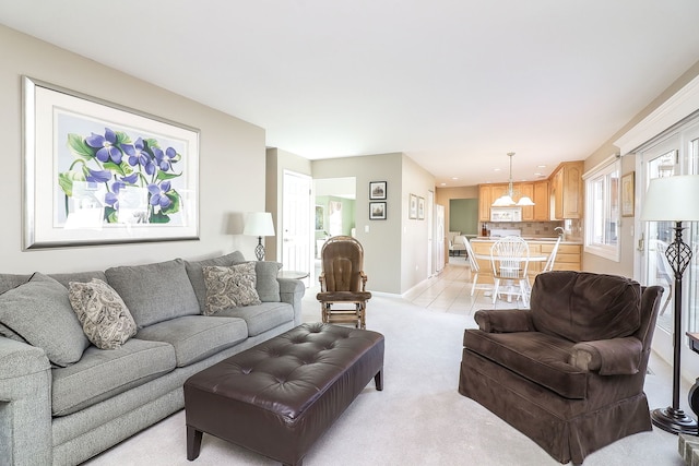 living room with baseboards and light colored carpet