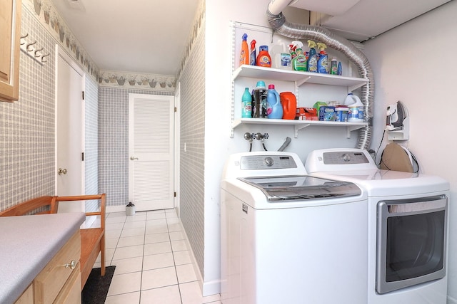 laundry room with wallpapered walls, cabinet space, light tile patterned floors, and separate washer and dryer