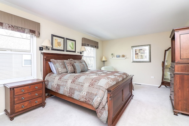 bedroom with baseboards and light carpet