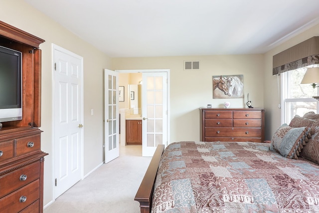 bedroom featuring visible vents, light colored carpet, and french doors