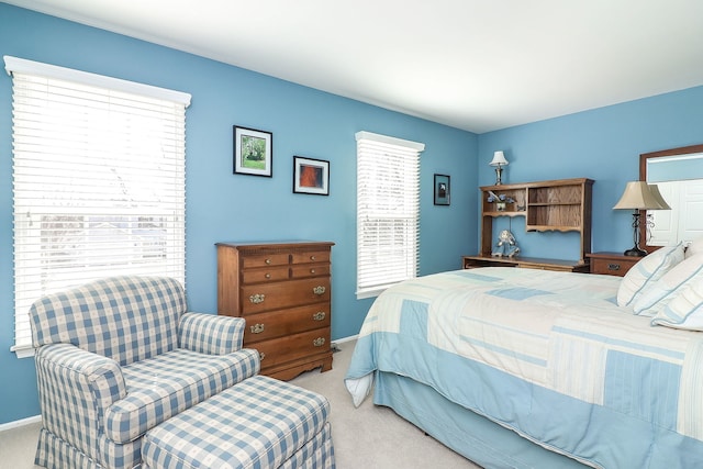 carpeted bedroom with multiple windows and baseboards