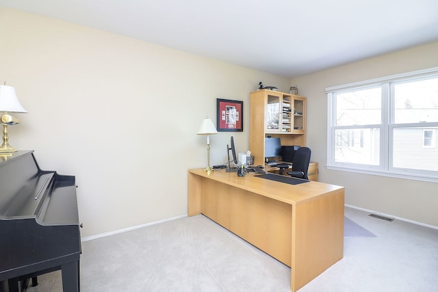 office space featuring light carpet, visible vents, and baseboards