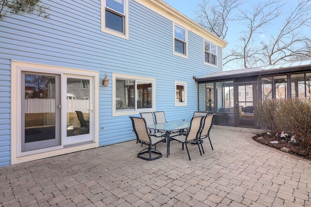 view of patio / terrace with outdoor dining area and a sunroom