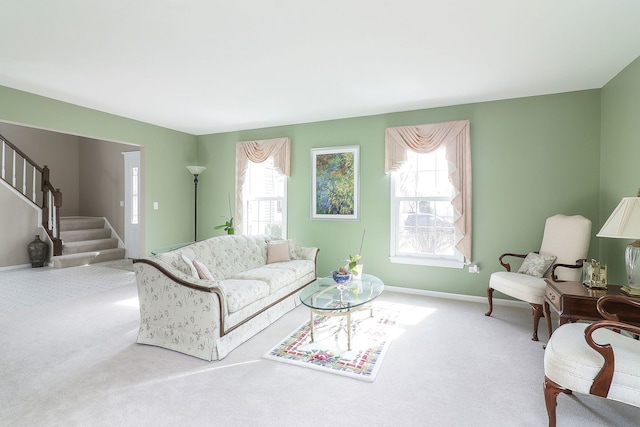 carpeted living room featuring a healthy amount of sunlight, stairs, and baseboards