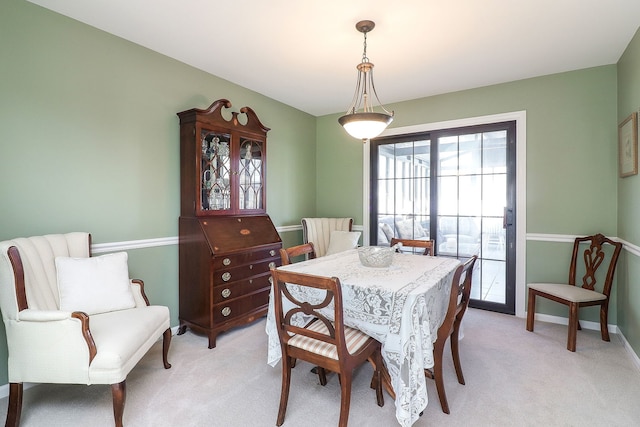 dining area with baseboards and light carpet