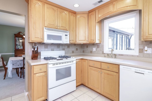 kitchen featuring a sink, visible vents, white appliances, and light brown cabinetry