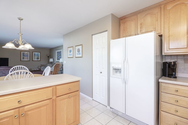 kitchen with light brown cabinets, light tile patterned flooring, light countertops, white refrigerator with ice dispenser, and tasteful backsplash