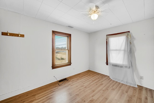 spare room featuring visible vents, ceiling fan, and wood finished floors