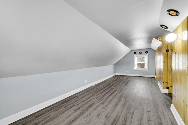 additional living space featuring lofted ceiling, baseboards, and wood finished floors