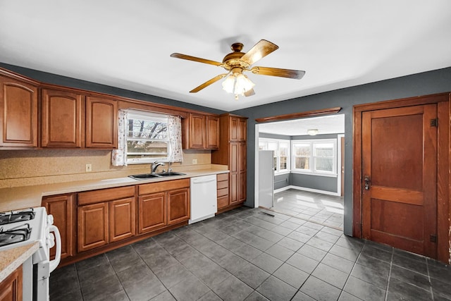 kitchen with a healthy amount of sunlight, dishwasher, a sink, and gas range oven