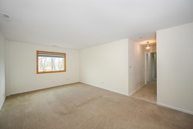unfurnished room featuring baseboards, visible vents, and light colored carpet