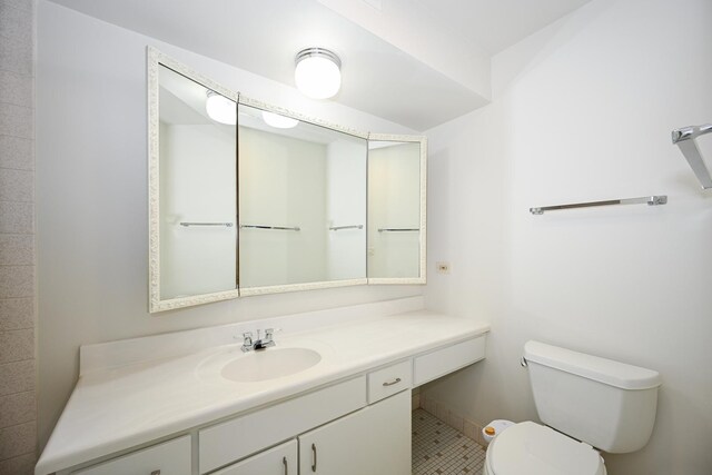 bathroom with toilet, vanity, and baseboards