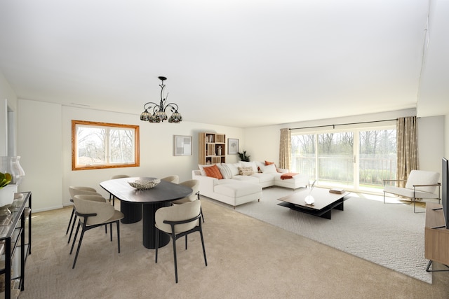 dining area featuring an inviting chandelier and light colored carpet
