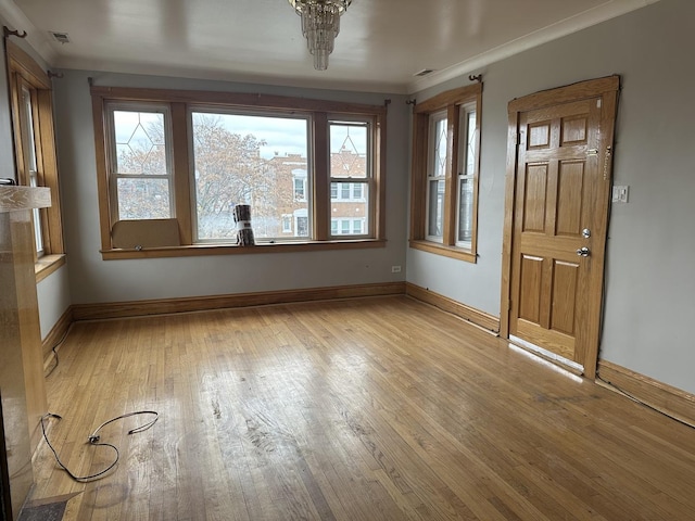 interior space with ornamental molding, visible vents, light wood-style flooring, and baseboards