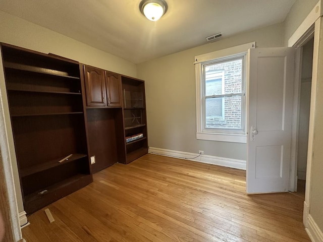 unfurnished bedroom featuring light wood-type flooring, visible vents, and baseboards