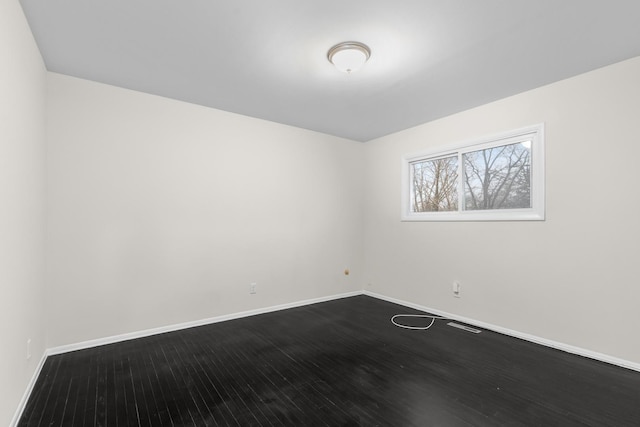 unfurnished room featuring dark wood-style floors and baseboards