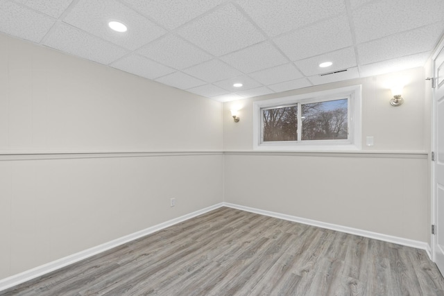 basement featuring baseboards, visible vents, a drop ceiling, wood finished floors, and recessed lighting