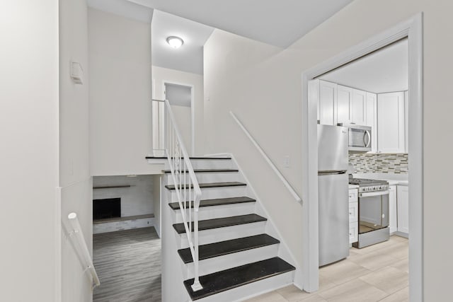 staircase featuring a fireplace and wood finished floors