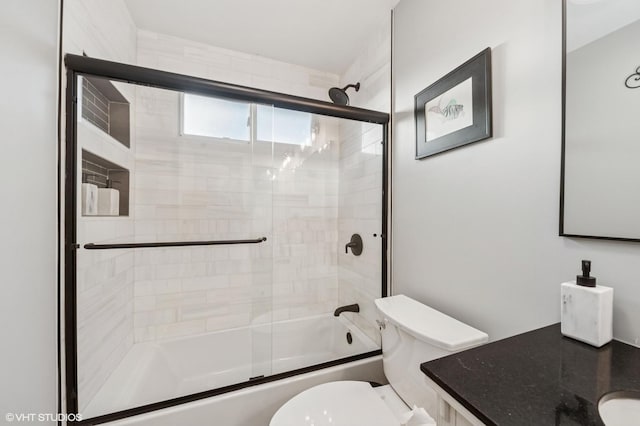 full bath featuring toilet, shower / bath combination with glass door, and vanity