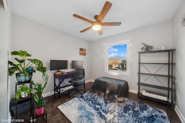 office space featuring ceiling fan and baseboards