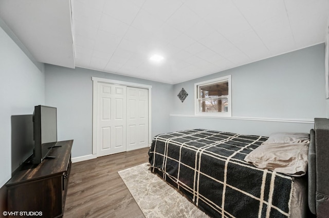 bedroom with a closet, baseboards, and wood finished floors