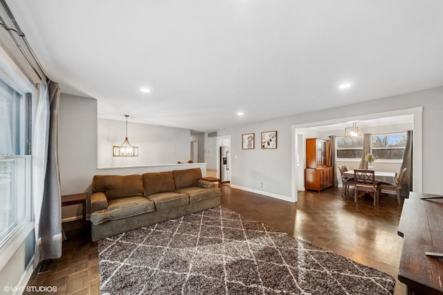 living room featuring visible vents, baseboards, parquet floors, a notable chandelier, and recessed lighting