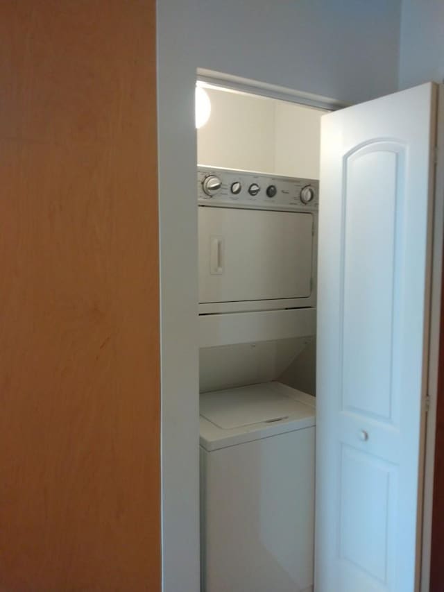 clothes washing area with laundry area and stacked washer / drying machine