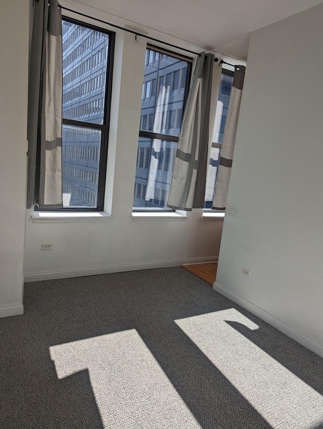 carpeted spare room with a wealth of natural light and baseboards