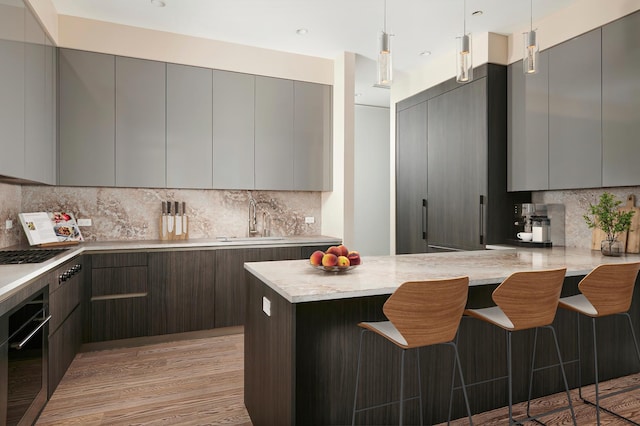 kitchen with oven, a sink, gray cabinetry, and modern cabinets