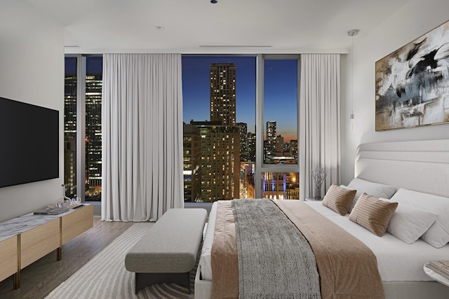 bedroom featuring a wall of windows and wood finished floors