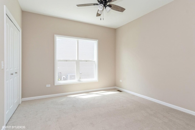 empty room with ceiling fan, visible vents, baseboards, and light colored carpet