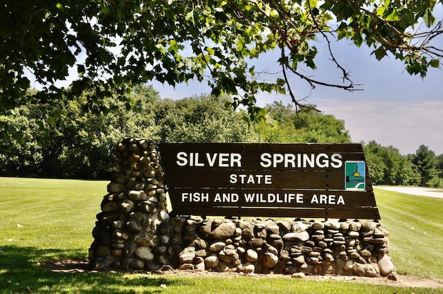 community / neighborhood sign featuring a lawn