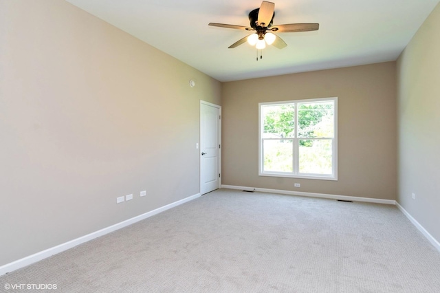 spare room featuring carpet, ceiling fan, and baseboards