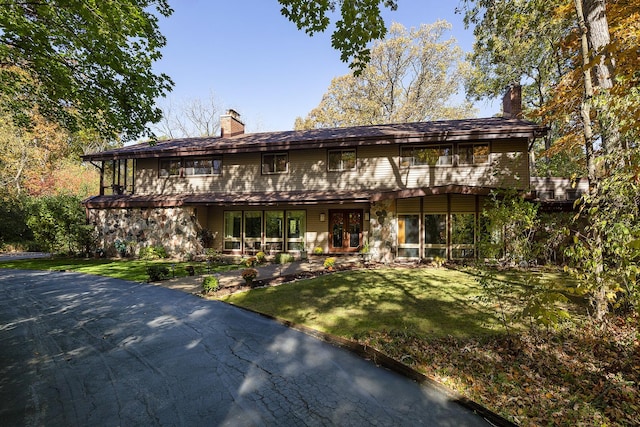 view of front of property with a chimney and a front yard