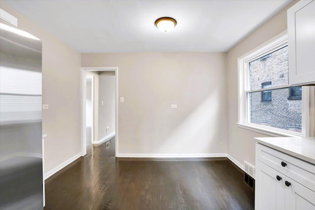 empty room featuring dark wood-style floors and baseboards