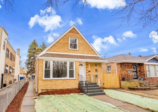 bungalow-style home featuring fence and brick siding