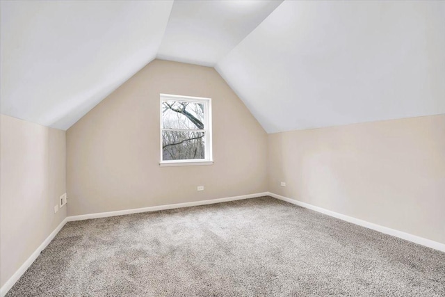 additional living space with carpet floors, lofted ceiling, and baseboards