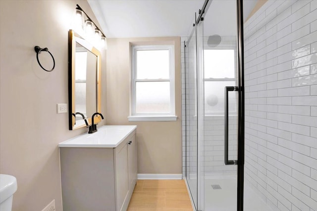 full bath with baseboards, toilet, a shower stall, and vanity