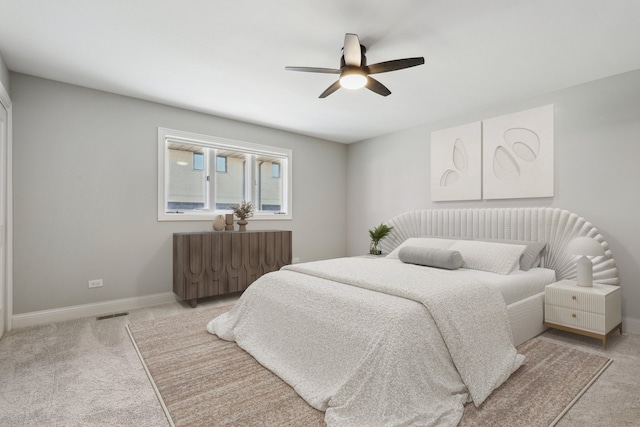 bedroom featuring baseboards, light carpet, and a ceiling fan