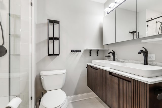 full bath with double vanity, toilet, baseboards, and a sink