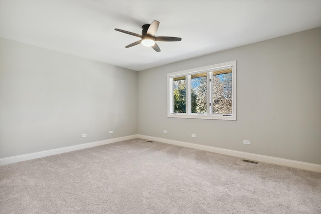 spare room featuring a ceiling fan, carpet, visible vents, and baseboards