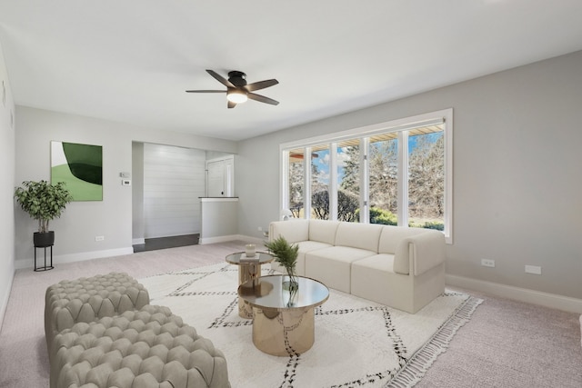 living area featuring baseboards, carpet floors, and a ceiling fan