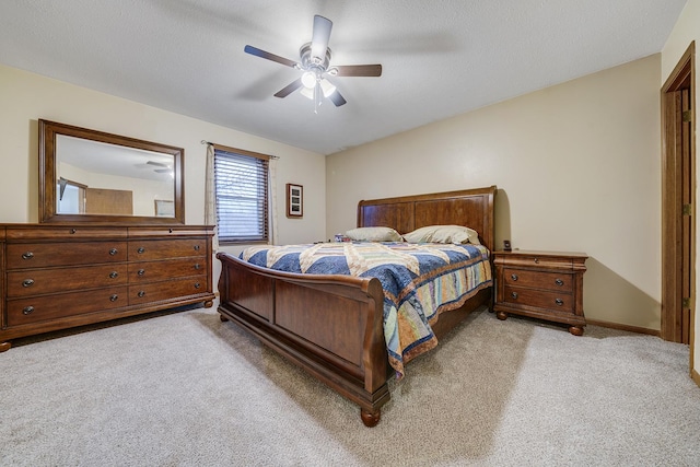 bedroom featuring light carpet, ceiling fan, a textured ceiling, and baseboards