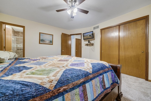 carpeted bedroom featuring a closet, visible vents, ceiling fan, and ensuite bath