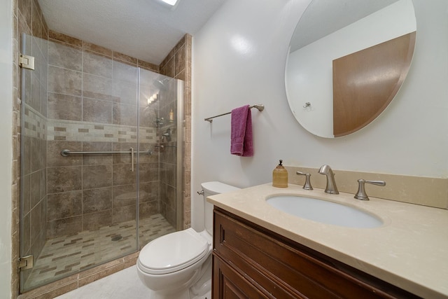 bathroom featuring toilet, a stall shower, a textured ceiling, and vanity