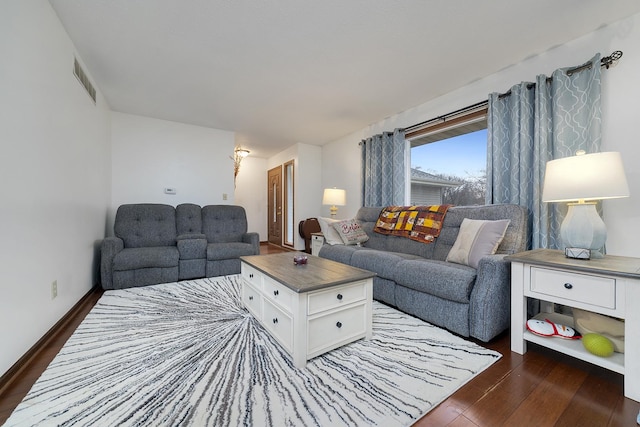 living room featuring dark wood-style floors, visible vents, and baseboards