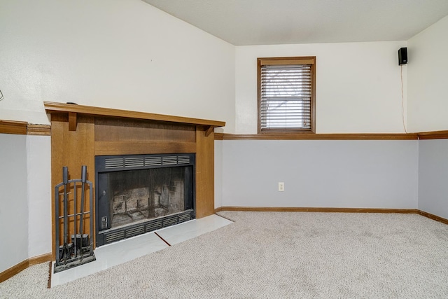 unfurnished living room featuring carpet, baseboards, and a fireplace with flush hearth